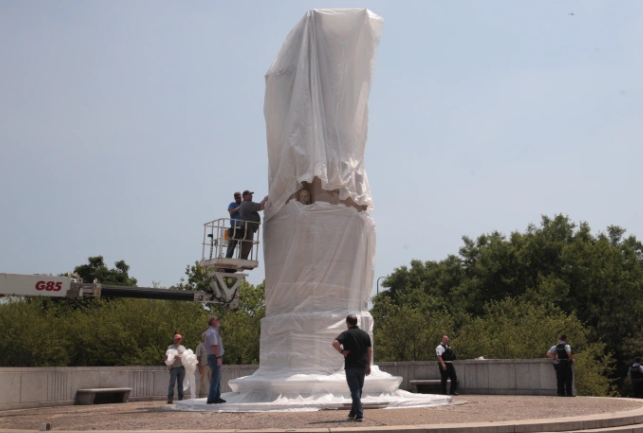 Workers covering a statue of Columbus in Chicago, IL on June 19, 2020. This was done before the Juneteenth march, a tribute to June 19, 1865; the date when those who were enslaved became emancipated.
