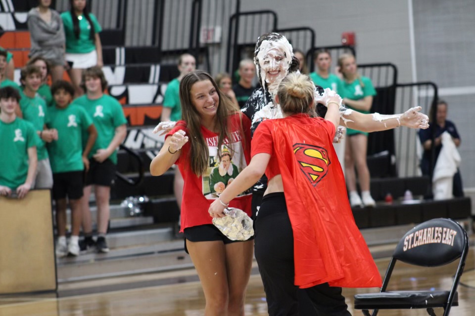 This years pie-in-the-eye winner, Taylor Cyr, being pied by seniors Allison Uchill (Left) and Grace Humes (Right). Photo by Lauren Voigt.
