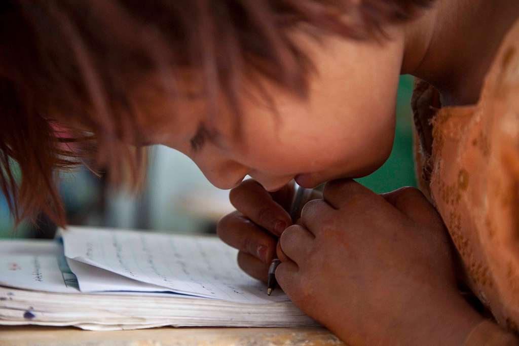 An Afghan girl practices her writing skills as she sits in a classroom in 2011. Photo Courtesy of PICRYL.