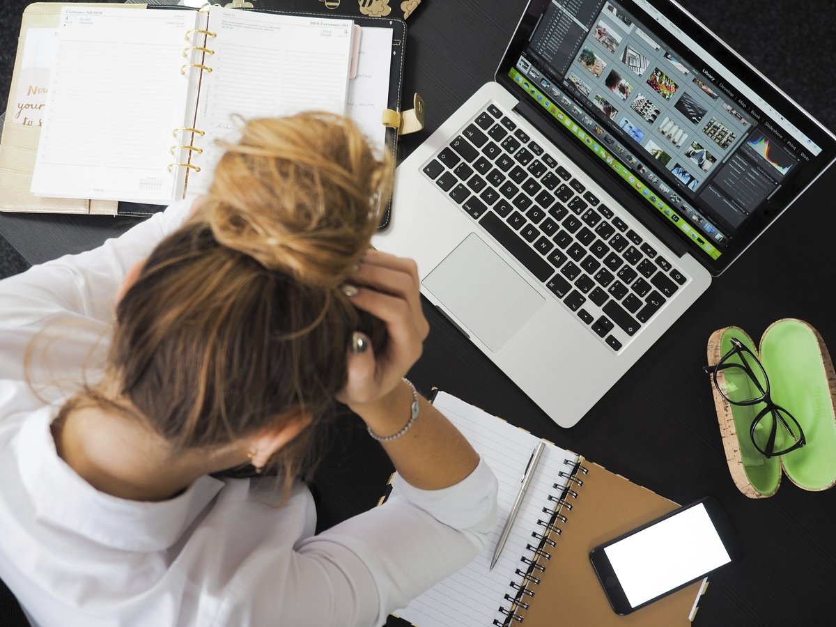 A person is stressed out as she works at her laptop. Photo courtesy of Raw Pixel.
