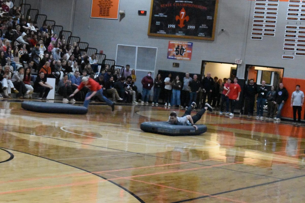 STCE PE teacher and volleyball Coach Matthew Caputo races the sophmores and seniors in the final round of the spring assembly air matress race. Photo courtesy of St. Charles East Flickr.