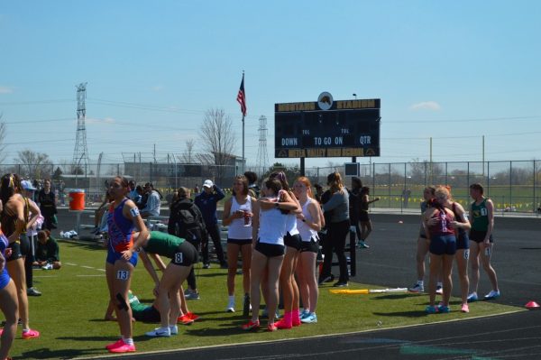 St Charles East girls’ track runners celebrate after a race at Metea Valley High School. Photo by Julie Garcia.