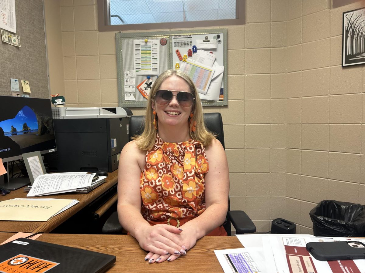 Nicole Osborne poses in her office while wearing Wednesday’s spirit day outfit for homecoming week. Photo by Arjun Patel.