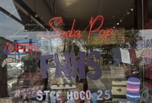 East's French National Honor Society (FNHS) paints the windows of Rocket Fizz in Downtown St. Charles for Homecoming. Photo by Arjun Patel.