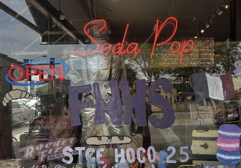 East's French National Honor Society (FNHS) paints the windows of Rocket Fizz in Downtown St. Charles for Homecoming. Photo by Arjun Patel.