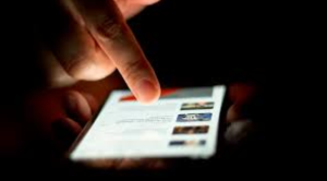 A person scrolls on their phone. Photo courtesy of Wikipedia Commons.